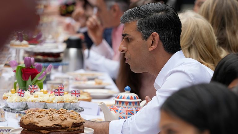 Prime Minister Rishi Sunak speaks to guests as he attends the Big Lunch party at Downing Street in London Sunday, May 7, 2023. The Big Lunch is part of the weekend of celebrations for the Coronation of King Charles III. Guests at the big lunch include community heroes and Ukrainians displaced by the war, and youth groups
Pic:AP