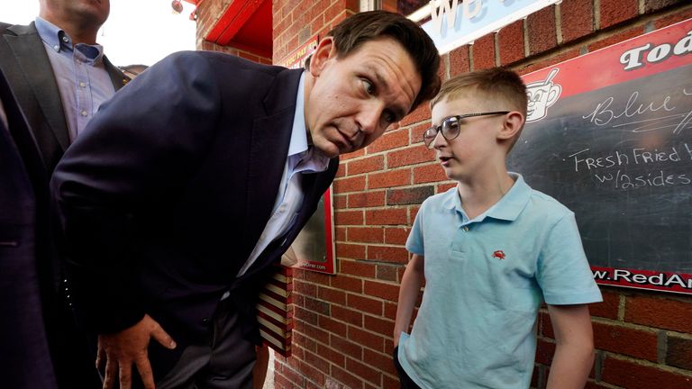 Florida Gov. Ron DeSantis leans in to listen to Elliot Perry outside the Red Arrow Diner during a visit to Manchester, N.H., Friday, May 19, 2023. (AP Photo/Robert F. Bukaty)