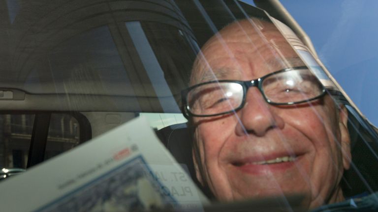 The media magnate is photographed reading The Sun newspaper as he is driven away from his central London home in 2012 