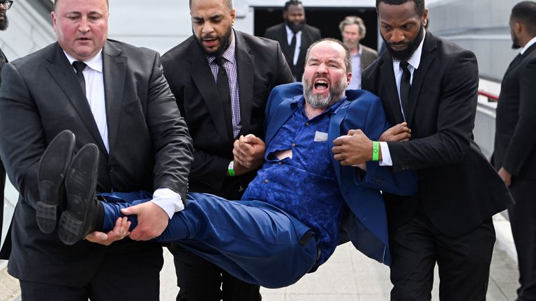 Security personnel remove a protester during the Fossil Free London demonstration outside the venue of Shell&#39;s annual shareholder meeting, at the ExCeL 