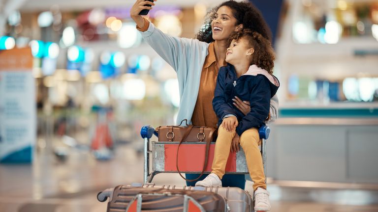 Mother and daughter take a selfie at an airport
