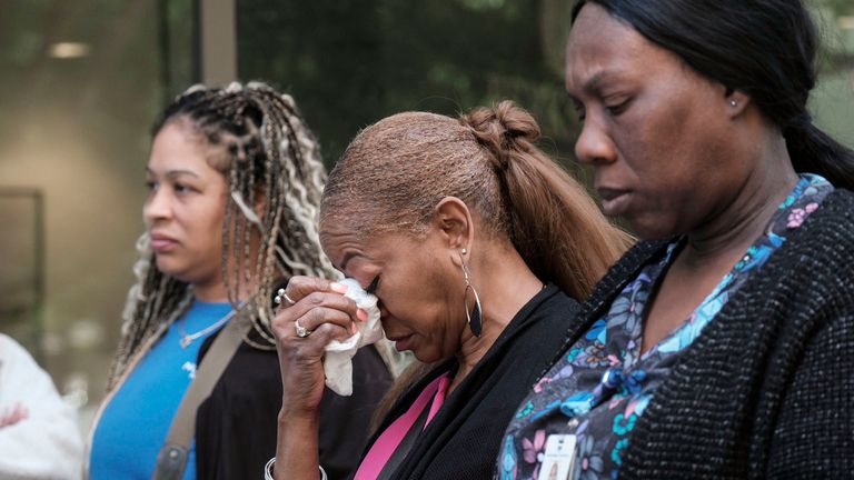 People stand outside a commercial building after a shooting, Wednesday, May 3, 2023, in Atlanta. Atlanta police said there had been no additional shots fired since the initial shooting unfolded inside a building in a commercial area with many office towers and high-rise apartments. (AP Photo/Ben Gray)