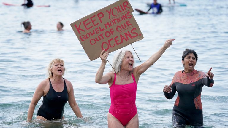 A lady holds a placard as Surfers Against Sewage hold a UK-wide paddle-out protest at Brighton West Pier in East Sussex, demanding an end to sewage discharges into UK bathing waters by 2030. Picture date: Saturday May 20, 2023.