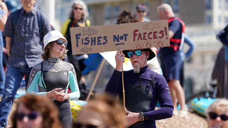 A person holds up a placard as Surfers Against Sewage hold a UK-wide paddle-out protest at Brighton West Pier in East Sussex, demanding an end to sewage discharges into UK bathing waters by 2030. Picture date: Saturday May 20, 2023.