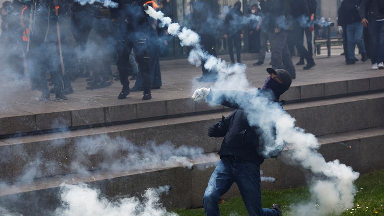 A demonstrator throws a tear gas during the traditional May Day labour march, a day of mobilisation against the French pension reform law and for social justice, in Nantes, France May 1, 2023. REUTERS/Stephane Mahe
