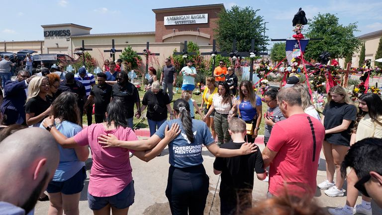 People pray at a makeshift memorial at the scene of the shooting.  photo: AP