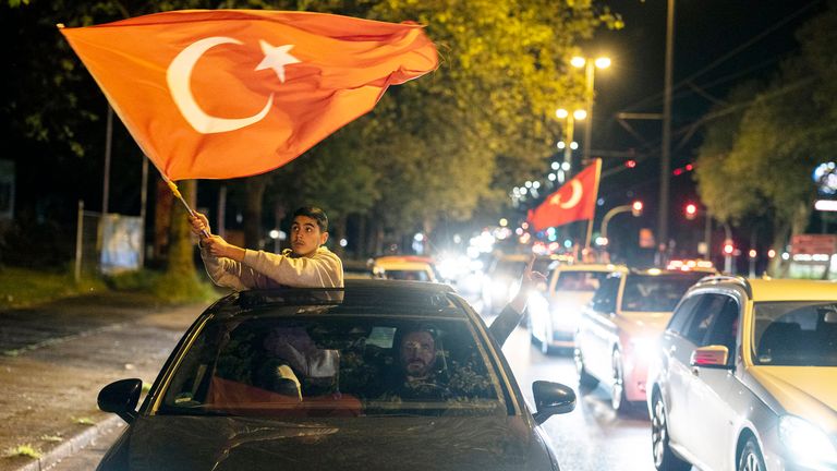 On the evening of the election in Turkey, supporters of incumbent Recep Tayyip Erdogan wave flags as they drive their cars through the streets of Duisburg, North Rhine-Westphalia, Germany, on Sunday, May 14, 2023. (Christoph Reichwein/dpa via AP)
