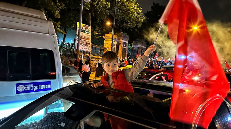 A boy holding a Turkish flag after the election