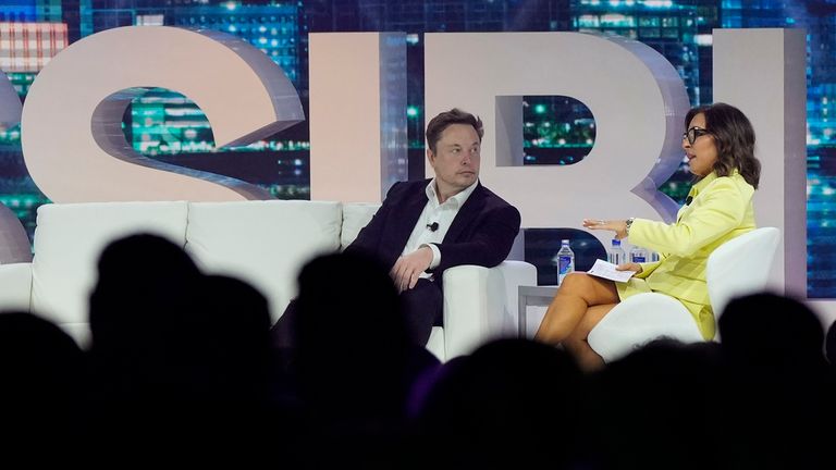 Twitter CEO Elon Musk, center, speaks with Linda Yaccarino, chairman of global advertising and partnerships for NBC, at the POSSIBLE marketing conference, Tuesday, April 18, 2023, in Miami Beach, Fla. (AP Photo/Rebecca Blackwell)