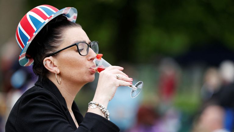 A woman drinks as she attends a picnic in a garden at Windsor Castle, a day after the coronation of Britain&#39;s King Charles, in Windsor, Britain May 7, 2023. REUTERS/Stephanie Lecocq..