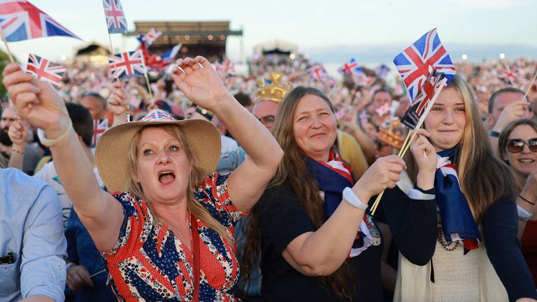 People wave flags prior to a concert at Windsor Castle in Windsor
Pic:AP