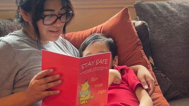 Cindy Campos reads the book "Stay Safe" to her son in Dallas. Cindy Campos&#39; 5-year-old son was so excited about the book that had been sent home with him from school featuring Winnie-the-Pooh that he wanted to read it immediately. But her heart sank as she flipped through the pages advising children what to do if ...danger is near,... including locking doors, turning off the lights and quietly hiding till police arrive. (Cindy Campos via AP)