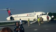 Airport and emergency personnel are on the scene as a  Delta plane lands without its landing gear at the Charlotte Douglas International Airport, 
Pic:AP