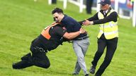 A protestor is tackled by police and stewards prior to the start of the Betfred Derby during Derby Day of the 2023 Derby Festival at Epsom Downs Racecourse, Epsom. Picture date: Saturday June 3, 2023.