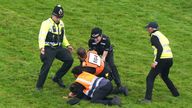 A protestor is escorted off the track by police and stewards during the Betfred Derby during Derby Day of the 2023 Derby Festival at Epsom Downs Racecourse, Epsom. Picture date: Saturday June 3, 2023.