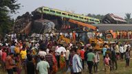 People stand next to damaged coaches after two passenger trains collided in Balasore district in the eastern state of Odisha, India, June 3, 2023. REUTERS/Stringer NO RESALES. NO ARCHIVES. TPX IMAGES OF THE DAY