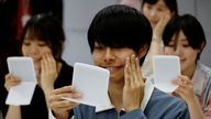 Students learn how to practice facial muscles with mirrors at a smile training course at Sokei Art School in Tokyo, Japan, May 30, 2023. REUTERS/Kim Kyung-Hoon