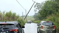 Cars pass a leaning power pole after Tropical Storm Bret passed north of the island, in St. Thomas, Barbados June 22, 2023. REUTERS/Nigel R. Browne