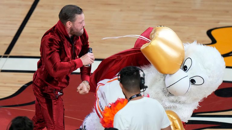 Former MMA fighter Conor McGregor punches Burnie, the Miami Heat mascot. Pic: AP