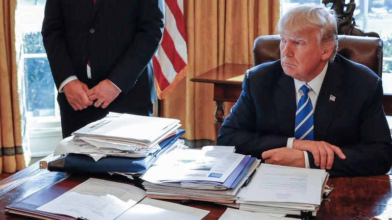 President Donald Trump sits at his desk after a meeting with Intel CEO Brian Krzanich in the Oval Office of the White House in Washington, Feb. 8, 2017