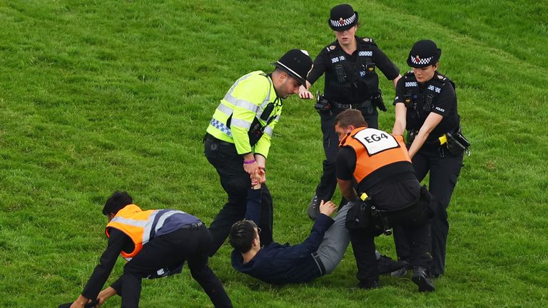 Horse Racing - Epsom Derby Festival - Epsom Downs Racecourse, Epsom, Britain - June 3, 2023 Protestor is removed from the race track by police officers during the 13:30 Betfred Derby Action Images via Reuters/Matthew Childs