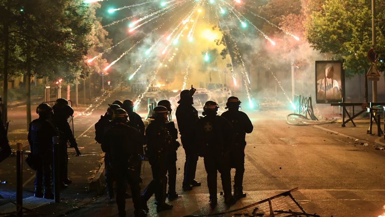 Police stand amid firecrackers on the third night of protests in Nanterre Pic: AP/Aurelien Morissard)