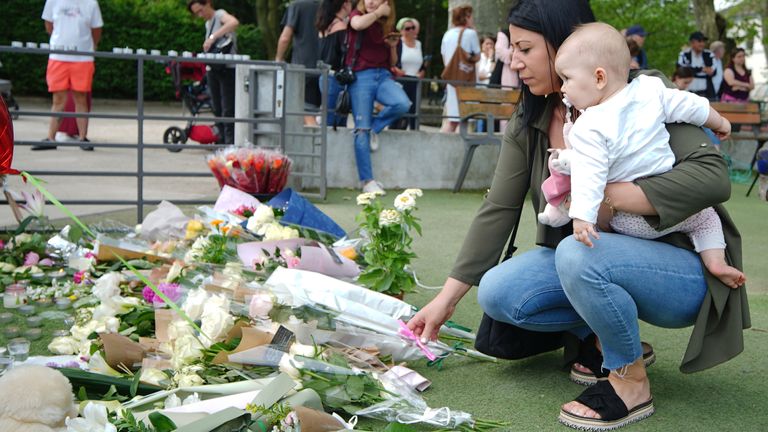 A woman holding a baby lays flowers near the scene at a lakeside park in Annecy, France, following a knife attack in which a British girl, said to be aged three, was one of four children and two adults wounded when the suspect, identified by police as a 31-year-old Syrian national who has refugee status in Sweden, attacked people with a knife in the town of Annecy on Thursday. The knifeman had been denied asylum in France just days before the attack, according to a minister. Picture date: Friday June 9, 2023. PA Photo. The British girl injured in a knife attack at a lakeside park in the French Alps is in stable condition in hospital, according to reports. See PA story POLICE France . Photo credit should read: Peter Byrne/PA Wire.....