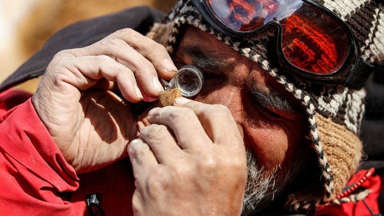 A paleontologist checks a fossilized bone of the &#39;Gonkoken nanoi&#39;, a newly identified duck-billed dinosaur, that inhabited the Chilean Patagonian area, at El valle del rio de las Chinas, near Torres del Paine, Magallanes and Antarctic region, Chile, in this undated handout photo obtained by Reuters on June 15, 2023. Universidad de Chile/ Handout via REUTERS THIS IMAGE HAS BEEN SUPPLIED BY A THIRD PARTY. MANDATORY CREDIT. NO RESALES. NO ARCHIVES
