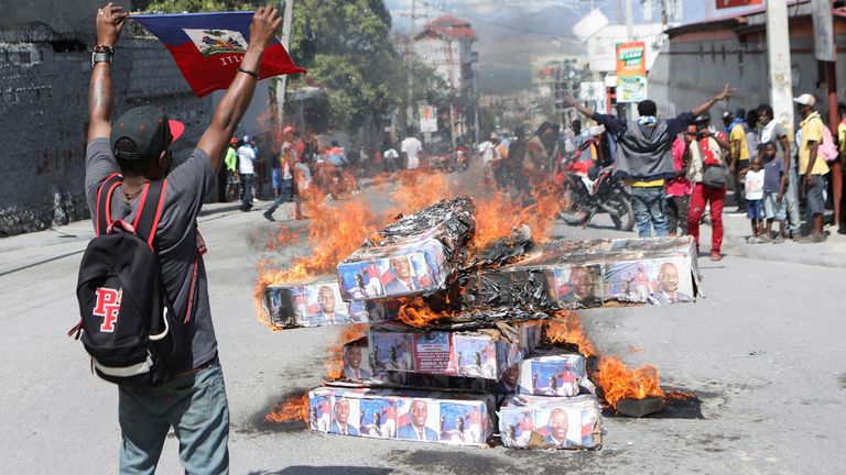 Supporters of Haiti&#39;s assassinated President Jovenel Moise, burn makeshift coffins with Moise pictures as an hommage to him, during a protest, in Port-au-Prince, Haiti, February 7, 2022. REUTERS/Ralph Tedy Erol
