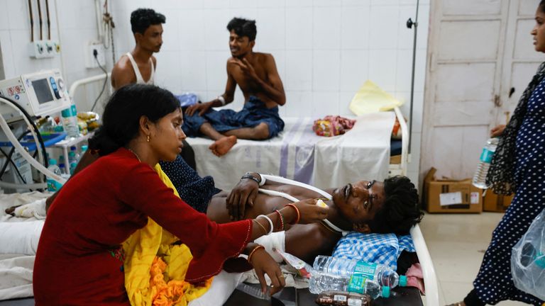Soma Palai, 21, wife of Gura Palai, 24, who was injured in trains collision, feeds her husband as he lies on a hospital bed in Balasore district in the eastern state of Odisha, India, June 3, 2023. REUTERS/Adnan Abidi