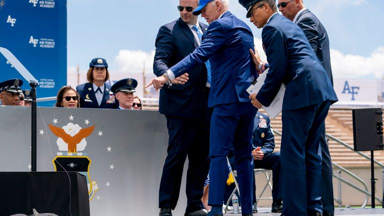 President Joe Biden points to sandbags after falling on stage. Pic: AP