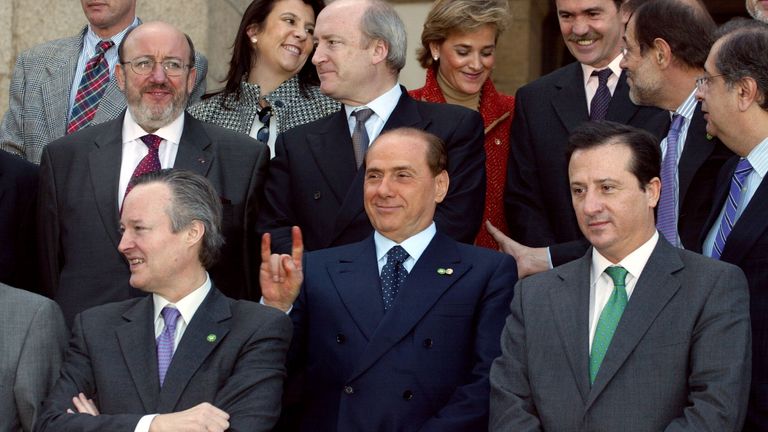     Italian Prime Minister and current Foreign Minister Silvio Berlusconi raises two fingers behind the head of then Spanish Foreign Minister Josep Piqué