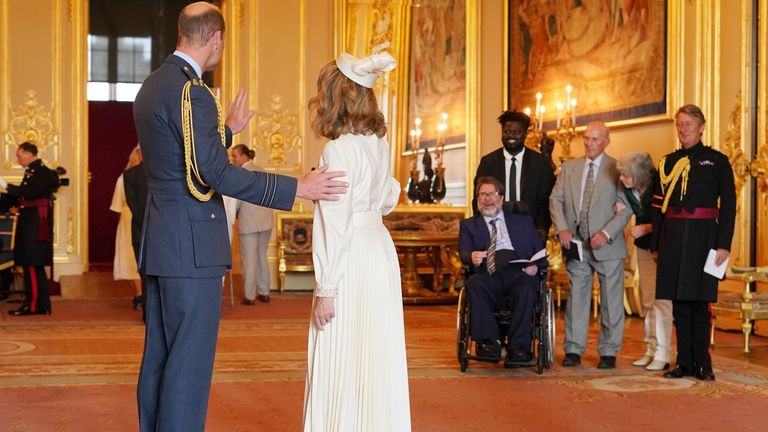 Kate Garraway, from London, is watched by her husband Derek Draper as she is made a Member of the Order of the British Empire by the Prince of Wales at Windsor Castle. The honour recognises services to broadcasting, to journalism and to charity.       Picture date: Wednesday June 28, 2023. PA Photo. See PA story ROYAL Investiture. Photo credit should read: Jonathan Brady/PA Wire