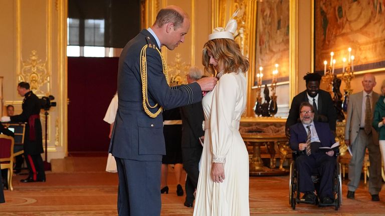 Kate Garraway, from London, is watched by her husband Derek Draper as she is made a Member of the Order of the British Empire by the Prince of Wales at Windsor Castle. The honour recognises services to broadcasting, to journalism and to charity.       Picture date: Wednesday June 28, 2023. PA Photo. See PA story ROYAL Investiture. Photo credit should read: Jonathan Brady/PA Wire