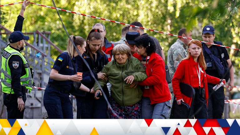 Emergency workers  support a woman, who recognised the bodies of her daughter and granddaughter killed during a Russian missile strike in Kyiv