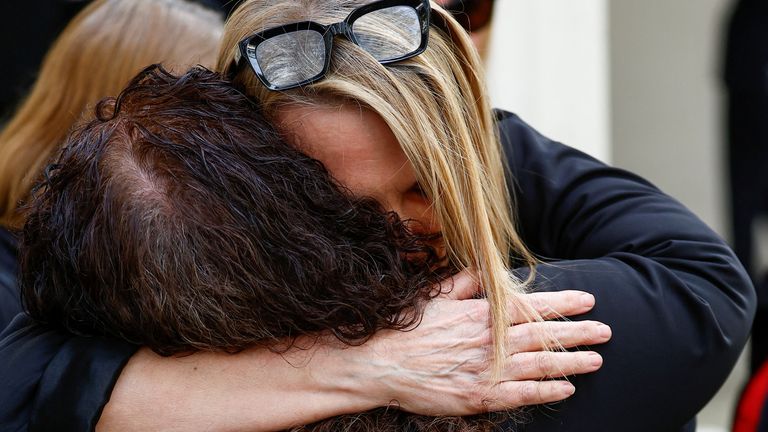 Lorelei King, who lost her husband Vincent Marzello to the coronavirus disease (COVID-19), holds an image of his coffin as she is embraced while Former British Health Secretary Matt Hancock arrives to give evidence at the COVID-19 Inquiry, in London, Britain, June 27, 2023 REUTERS/Peter Nicholls
