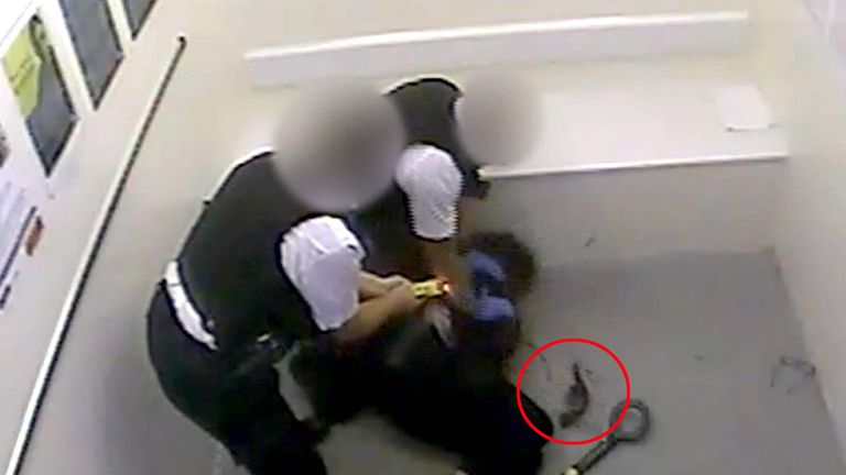 a weapon (circled in red) laying on the floor, as officers wrestle Louis De Zoysa to the floor, moments after Sergeant Matt Ratana was fatally shot inside a custody block at Croydon custody centre