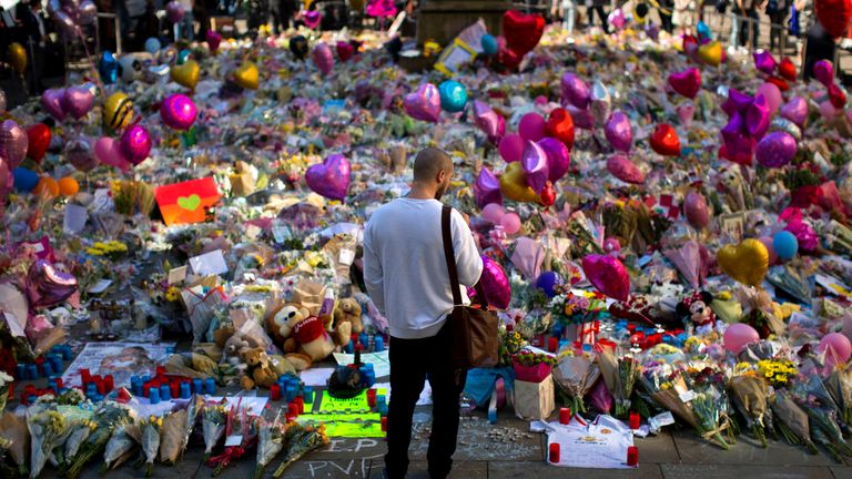 A man stands next to flowers for the victims of the bombing days after it took place. Pic: AP