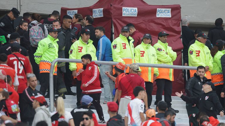 Police officers and security staff members secure an area where an accident involving a spectator who fell to his death, during a local tournament soccer match between River Plate and Defensa y Justicia, at the Monumental stadium in Buenos Aires, Argentina, Saturday, June 3, 2023.  (AP Photo/Nicolas Aboaf)