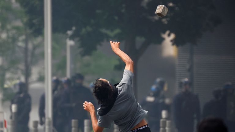 A masked protester throws a stone amid clashes with police during a march in tribute to Nahel, a 17-year-old teenager killed by a French police officer during a traffic stop, in Nanterre, Paris suburb, France, June 29, 2023. REUTERS/Sarah Meyssonnier
