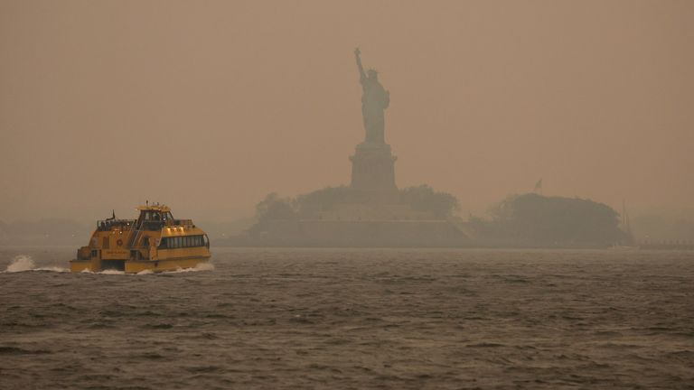 Smoke and smoke from wildfires in Canada hang over the Statue of Liberty in New York, U.S., June 6, 2023. REUTERS/Amr Alfiky
