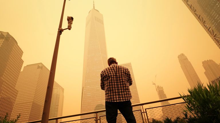 A man looks up at the One World Trade Center building