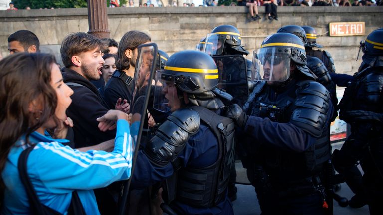 Police officers face protesters on Concorde square during a protest in Paris, France, Friday, June 30, 2023. French President Emmanuel Macron urged parents Friday to keep teenagers at home and proposed restrictions on social media to quell rioting spreading across France over the fatal police shooting of a 17-year-old driver. (AP Photo/Lewis Joly)