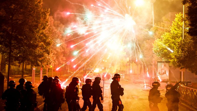 French police stand in position as fireworks go off during clashes with youth, after the death of Nahel, a 17-year-old teenager killed by a French police officer during a traffic stop, in Nanterre, Paris suburb, France, June 30, 2023. REUTERS/Gonzalo Fuentes
