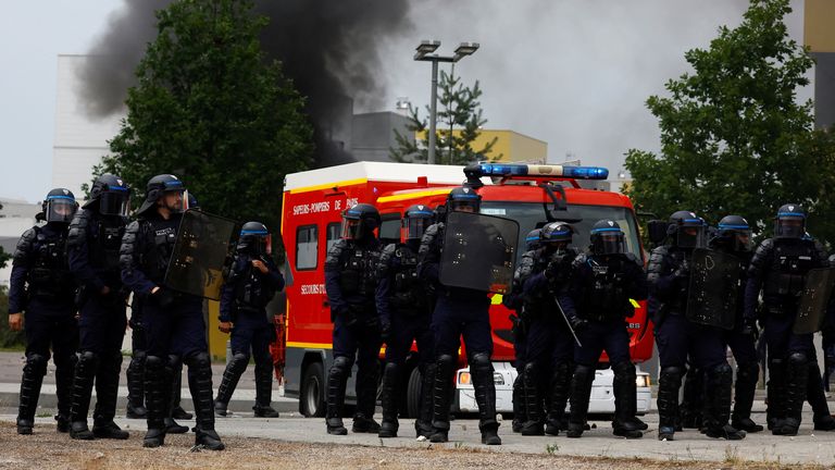 French riot police stand in position near a firefighter truck amid clashes with protesters during a march in tribute to Nahel, a 17-year-old teenager killed by a French police officer during a traffic stop, in Nanterre, Paris suburb, France, June 29, 2023. REUTERS/Sarah Meyssonnier
