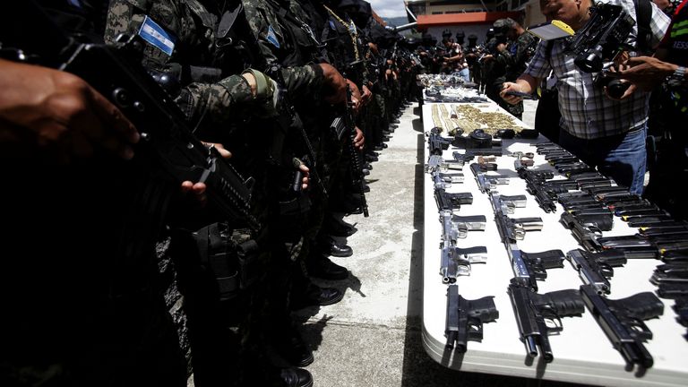 Members of the Military Police of Public Order stand guard, as they present bullets and weapons seized at Tamara prison after the Honduras Armed Forces took over the control of the prisons nationwide, as part of the 