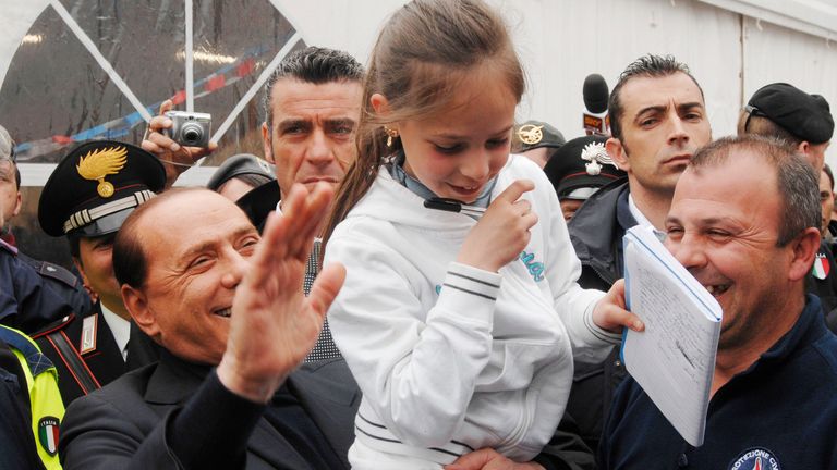 Italian Premier Silvio Berlusconi, left,  lifts Melissa Dionisi, in the tent-city, in Pianola, during his visit, near L&#39;Aquila, in the quake-stricken Abruzzo  
Pic:AP