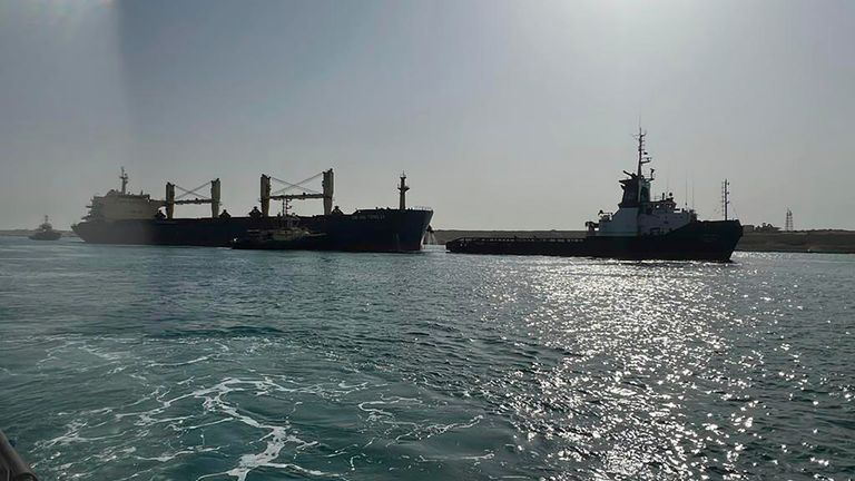 In this photo provided by The Suez Canal Authority in Egypt, the bulk carrier ship Xin Hai Tong 23, left, is towed after it ran aground at the southern mouth of the Suez Canal Thursday, May 25, 2023. The ship was being towed to another area by three tug boats after an "emergency malfunction," the authority said, that caused it to stop sailing, a rescue team of tugboats refloated it soon after. (Suez Canal Authority via AP)