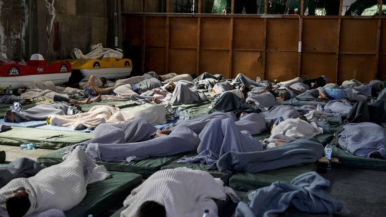 Survivors of a shipwreck sleep at a warehouse at the port in Kalamata town. Pic: AP