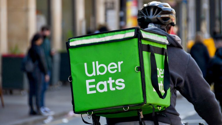 Cardiff, Wales - March 2022: Cycle courier for the Uber Eats food delivery service riding through the city centre